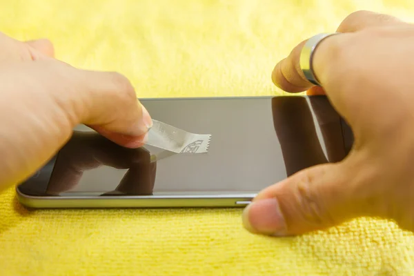 Limpieza de la pantalla del teléfono móvil mediante cinta adhesiva transparente — Foto de Stock