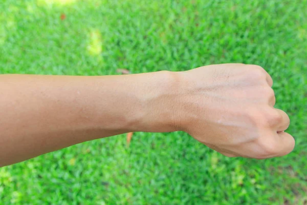 Wrist of man on the grass — Stock Photo, Image
