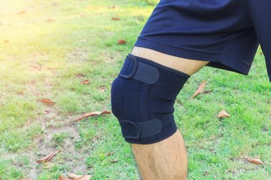 Adam dizlik destegi takiyor. Patella 'yi güneş isigi ile parka / diz altligi Delik Spor' a götürüyor.