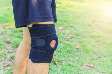 Adam dizlik destegi takiyor. Patella 'yi güneş isigi ile parka / diz altligi Delik Spor' a götürüyor.