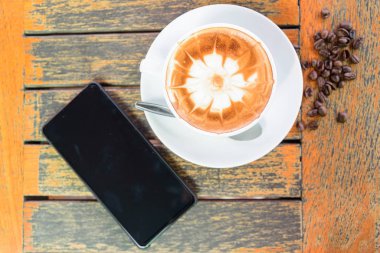 sıcak cappuccino güzel süt desen ve çalışma alanı tablosu Office'te akıllı telefon