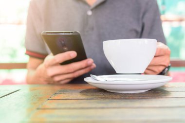 Akıllı telefon kullan ve içmek için sıcak kahve al.