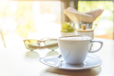 Sıcak kapuçino. Masanın üzerinde köpük desenli güzel bir kahve.