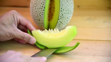 Bıçak kullanan adam yeşil karpuzu ahşap tabakta ikiye böldü.