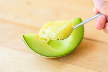 Tahta tabakta taze yeşil karpuzu kaşık kaşık dolaş.