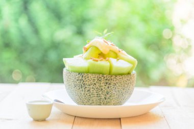 Tatlandırılmış konsantre sütle ahşap masada kavun Bingsu. 