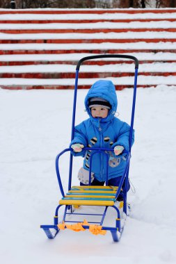 küçük çocuk bir kızak üzerinde paten sonra dinlenme