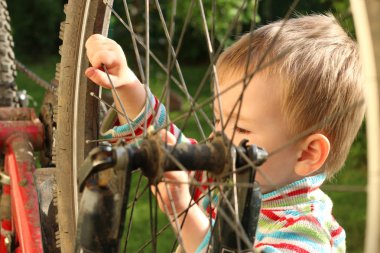 Yaz aylarında açık havada bisiklet tekerleği tamir bebeğim. Seçici odak.
