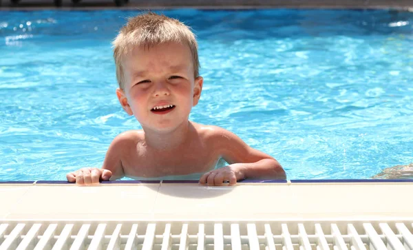 Il ragazzo biondo che impara a nuotare in piscina — Foto Stock