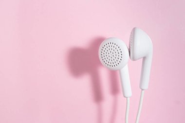 Açık pembe arka planda kulaklıklı beyaz. Kapalı üst görünüm.