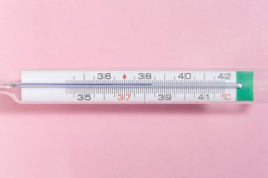 Pembe arka planda 38 santigrat derecede bir termometrenin ayrıntıları