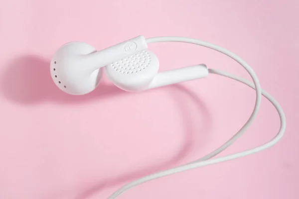 Auriculares Blancos Oído Sobre Fondo Rosa Claro Vista Superior Cerrada — Foto de Stock