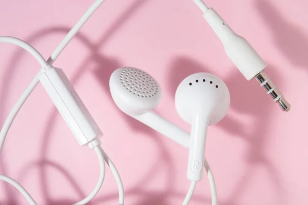 Auriculares Blancos Oído Sobre Fondo Rosa Claro Vista Superior Cerrada — Foto de Stock