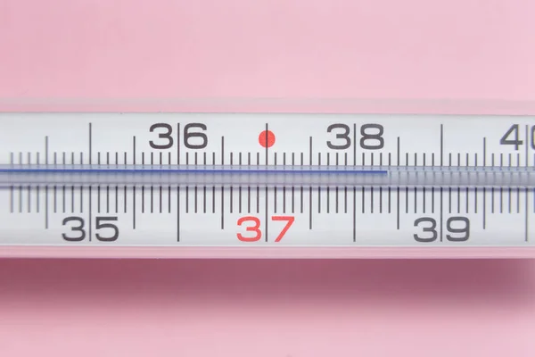 detail of a thermometer at 38 degrees Celsius on a pink background