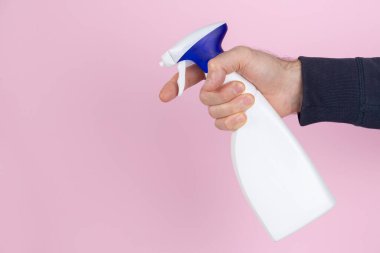 Sarı arka planda sprey sıkan bir adam.