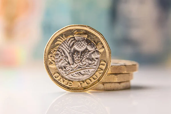 Arka planda 10 sterlin banknot olan bir sterlin.