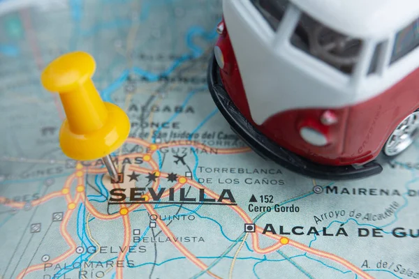 Seville city on the map. A camper van as a symbol of travel