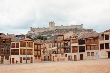 Peafiel, İspanya - 21 Nisan 2019. Peafiel 'deki Plaza del Coso manzarası. Arka planda şato var. Varlığı Orta Çağ 'dan beri belgelenmektedir. 48 binayla uyumlu, ahşap balkonları var..
