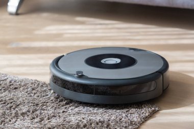 Robot elektrikli süpürge halı temizliyor.
