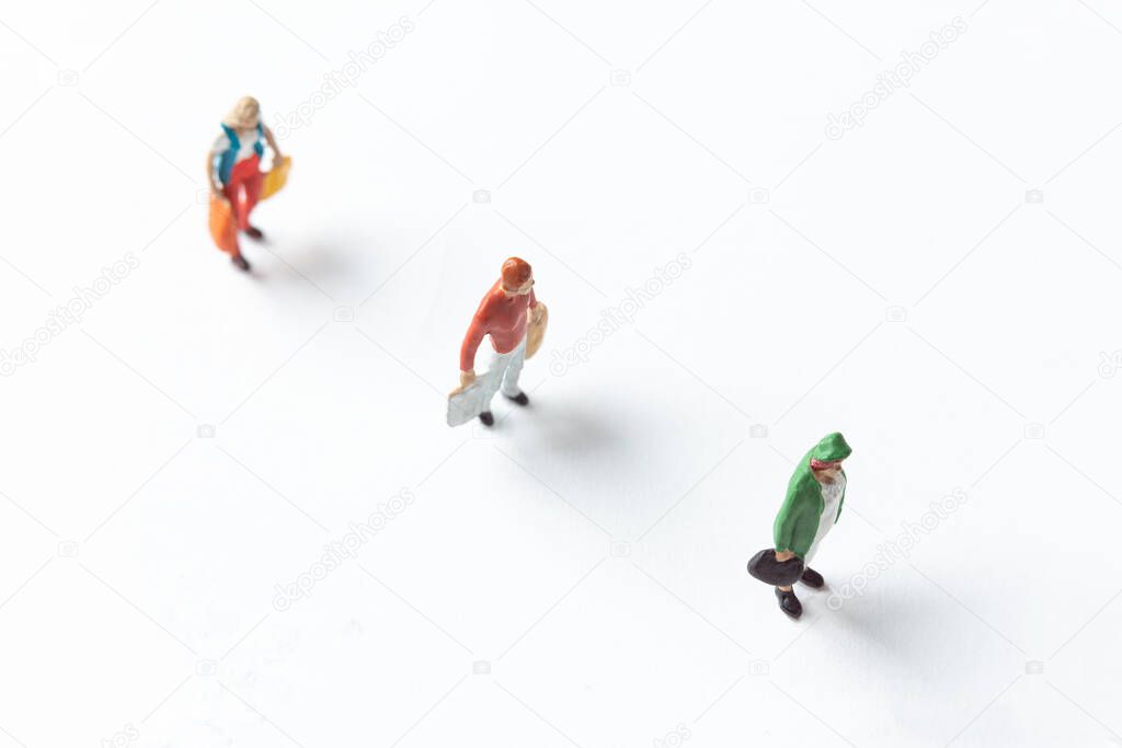 miniature people figures on white background with safety distance marked on the ground