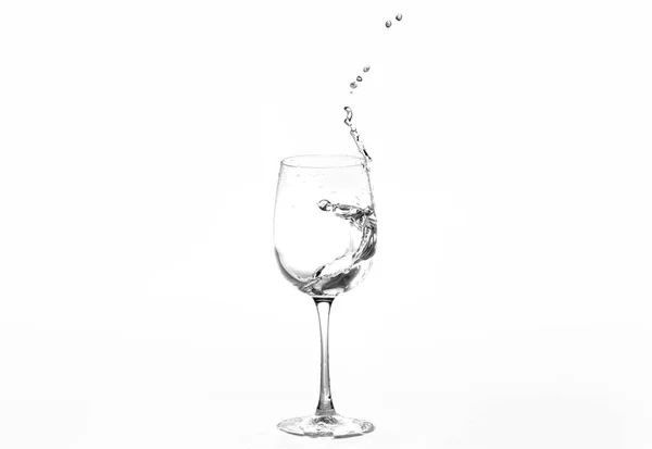 Horizontal photo of a splash of water in a glass for wine. Object isolated on a white background. — Stock Photo, Image