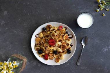 Karantina kahvaltısı, böğürtlen ve ballı ev yapımı küçük krepler, arka planda bir bardak süt ve papatya çayı, moda 2020