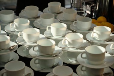 Bir grup boş beyaz bardağın deseni. Kahve ve çay için bir sürü beyaz kupa ya da bardak, kahvaltı ya da açık büfe için birbirlerinin üstünde duruyorlar.