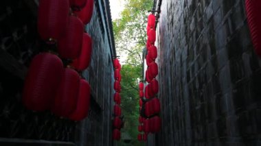 Çin tapınağının eski duvarları arasındaki dar koridorda yürüyorum. Fenerler çatıdan sarkıyor ve sallanıyor. Chengdu Wu Hou Tapınağı, Zhitongche manzaralı bir yer. Sinematik çekim.