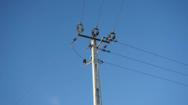 Mavi gökyüzüne karşı çimento elektrik kulesi