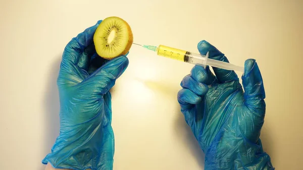 surgical needle injecting substance into kiwi against white background