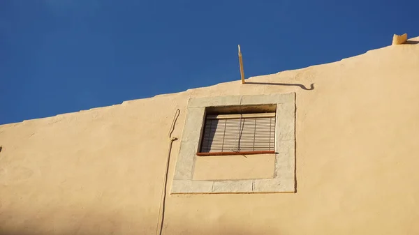 青い空に対する素朴な町の家の窓 — ストック写真