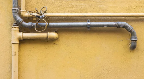 Viejas tuberías de agua y gas frente a una pared de yeso — Foto de Stock