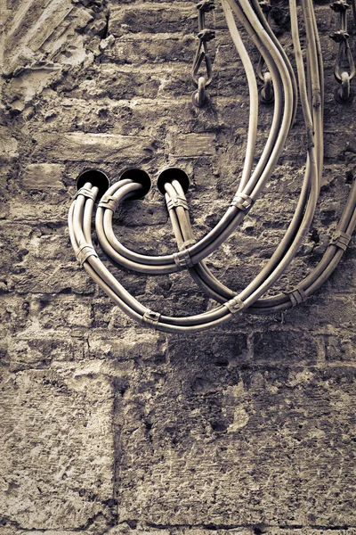 Electrical cables fixed on the wall for the distribution of electricity supply. (Toned image) — Stock Photo, Image