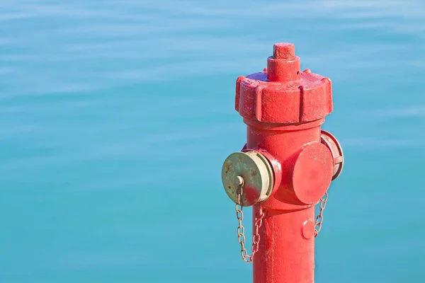 红色消防栓反对水背景-概念图象与 — 图库照片