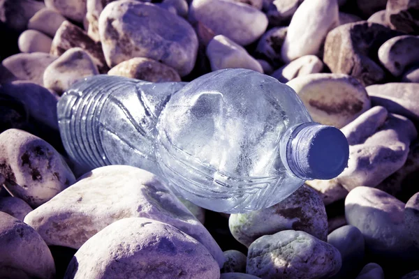 Lege plastic fles verlaten op grind strand - verkleinde afbeelding — Stockfoto
