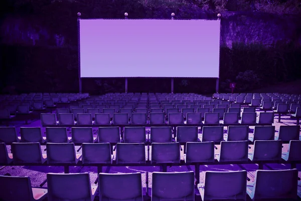 Cine al aire libre con sillas y pantalla de proyección blanca en la naturaleza — Foto de Stock