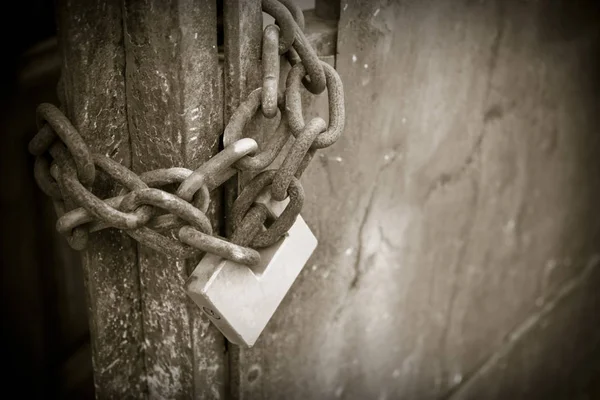 Metal gate closed with padlock - sepia toned — Stock Photo, Image