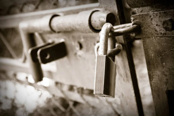 Puerta metálica oxidada de una fábrica cerrada con candado - concepto imag — Foto de Stock