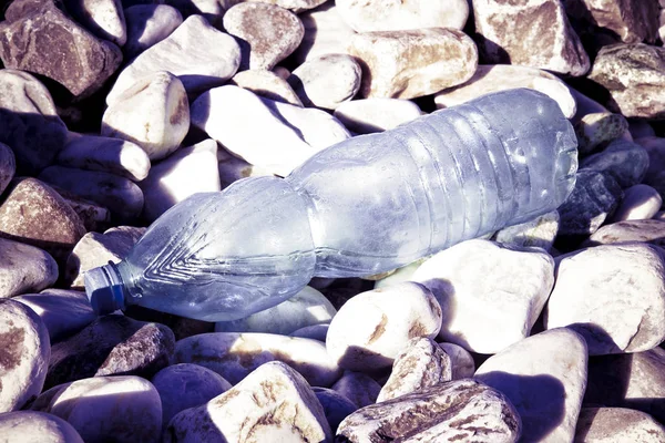 Lege plastic fles verlaten op grind strand - verkleinde afbeelding — Stockfoto