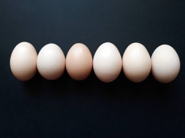 Arka planda altı tavuk yumurtası var..