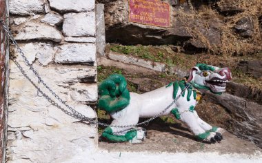Himalayalar 'ın başkenti Bhutan' da bulunan Thimphu yakınlarındaki Budist manastırı Chagri Cheri Dorjeden Manastırı 'nın girişinde zincirli fantastik bir ejderha köpeği figürü.. 