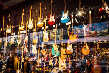 tel Aviv, İsrail - 29 Temmuz 2019. Modern bir müzik dükkanında asılı olan akustik elektro gitarlar..