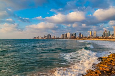 Güneşli bir günde modern Tel Aviv gökyüzü ve plajının panoramik manzarası. Akdeniz, İsrail 'de. Deniz dalgaları ve bulutlu gökyüzü.