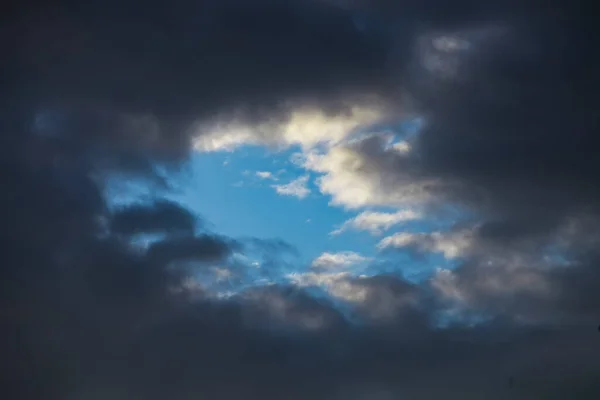蓝天中的暴风雨云 黑暗和光明 善与恶 天堂和地狱 暴风雨的天空背景上一片蓝色 — 图库照片