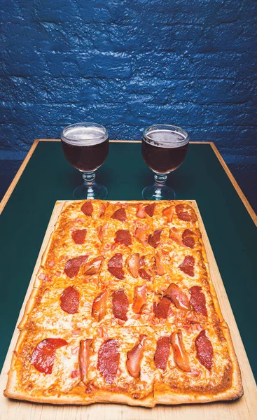 square pizza and beer in dark mood lighting vertical