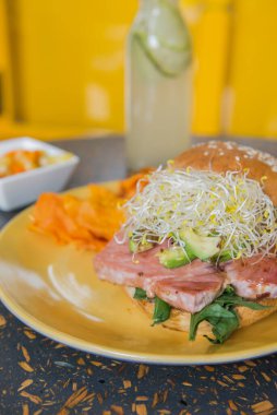 Güneşli masada ton balıklı simit.