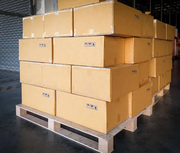 Stack of cardboard boxes on wooden pallets, package, packaging cartons, interior of warehouse storage, manufacturing plant shipping logistics and transport