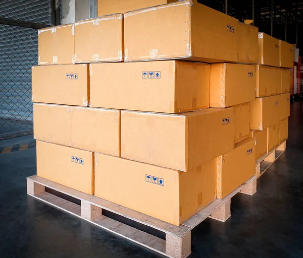 Stack of cardboard boxes on wooden pallets, package, packaging cartons, interior of warehouse storage, manufacturing plant shipping logistics and transport