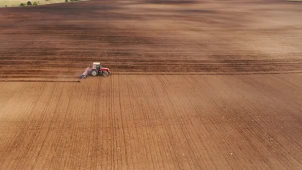 An aerial view of tractor planting potatoes in the fertile farm fields of Idaho, during the spring. — Stock Video