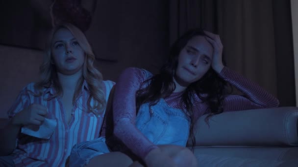 Дві молоді красиві сумні дівчата дивляться сумну мелодраму — стокове відео